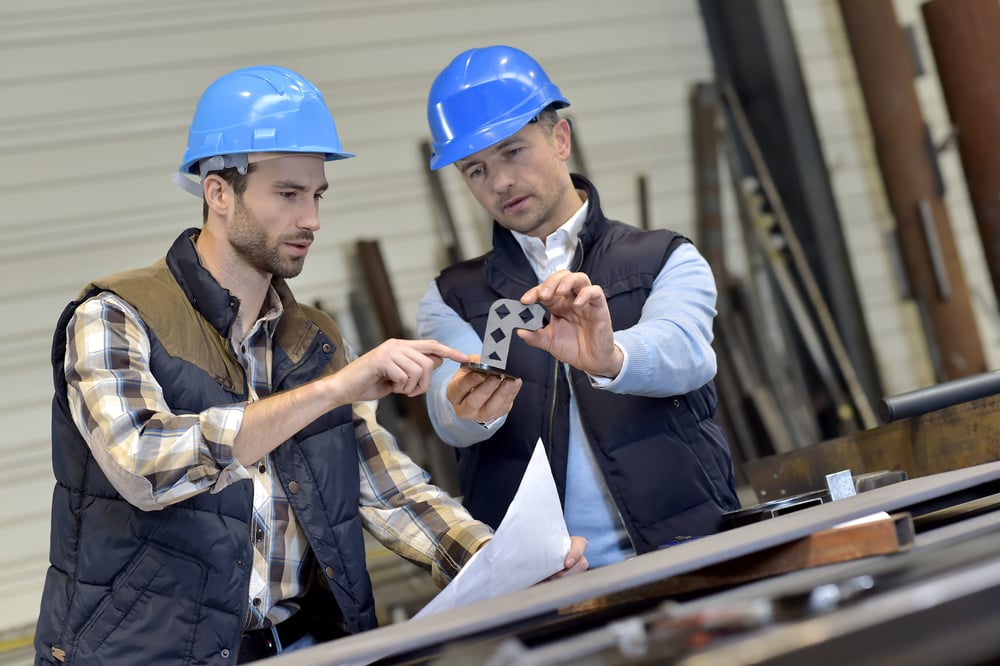 Engineer with mechanical worker checking on production