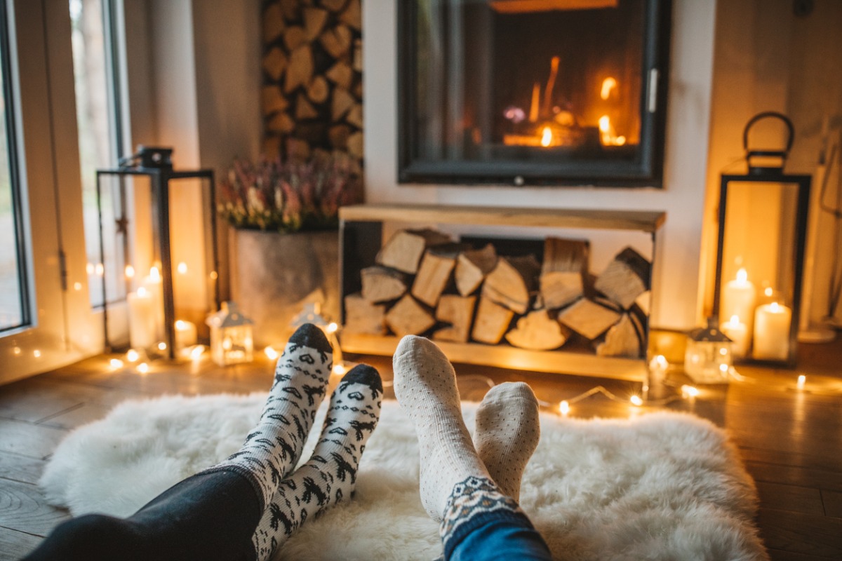 a happy couple relaxing by the fire 1200x800px