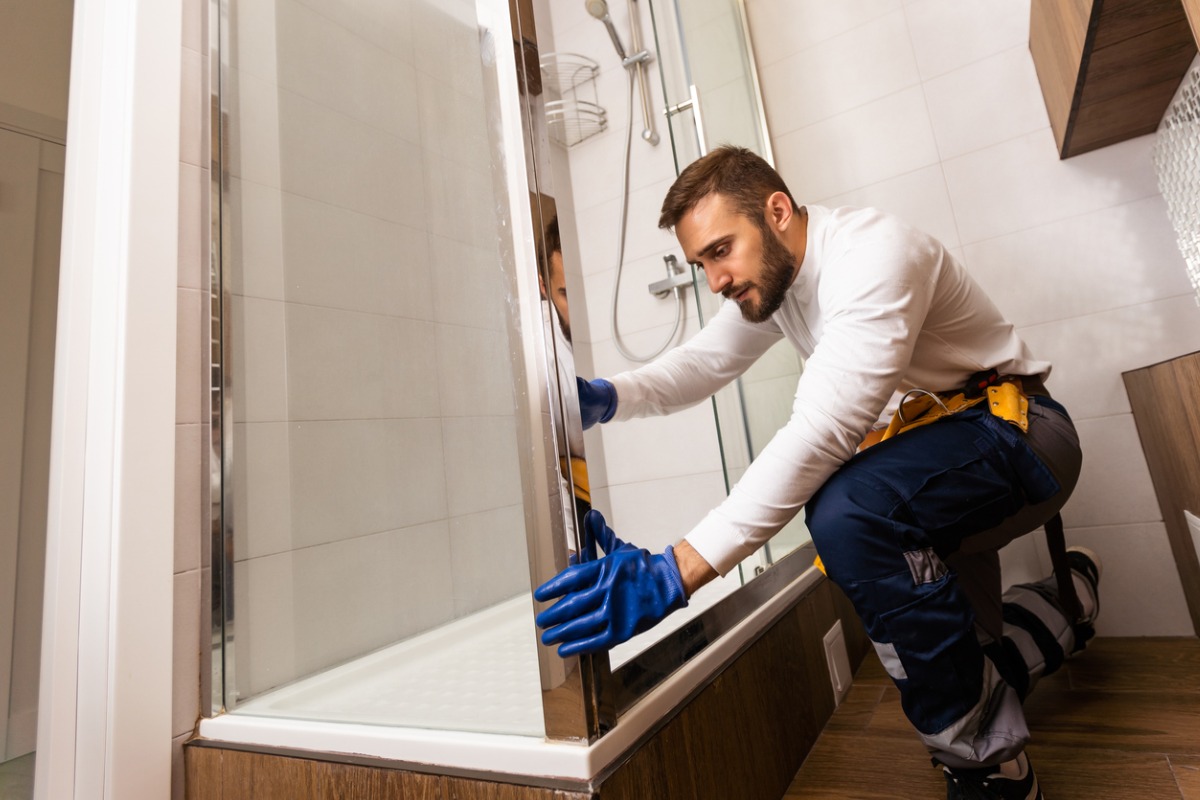 Professional bathroom fitter installing a shower screen 1200x800px