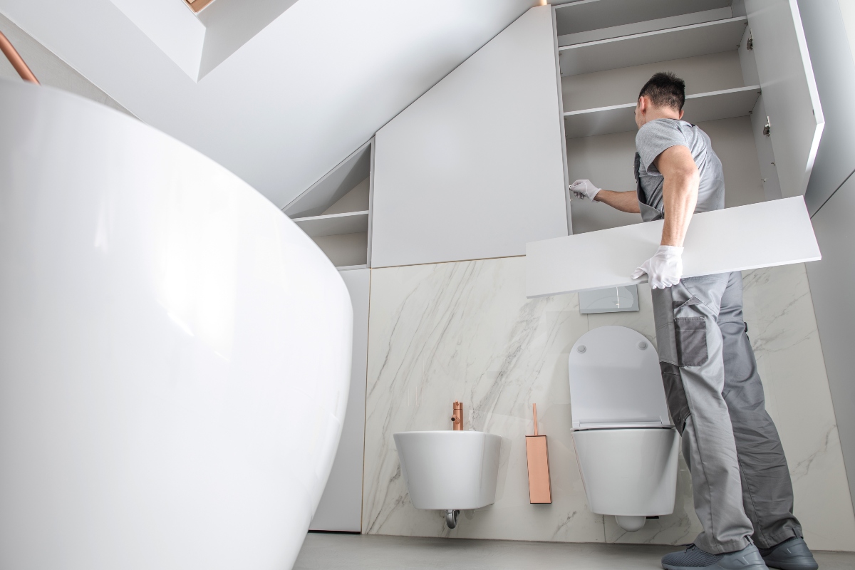 Professional bathroom fitter installing cabinets 1200x800px