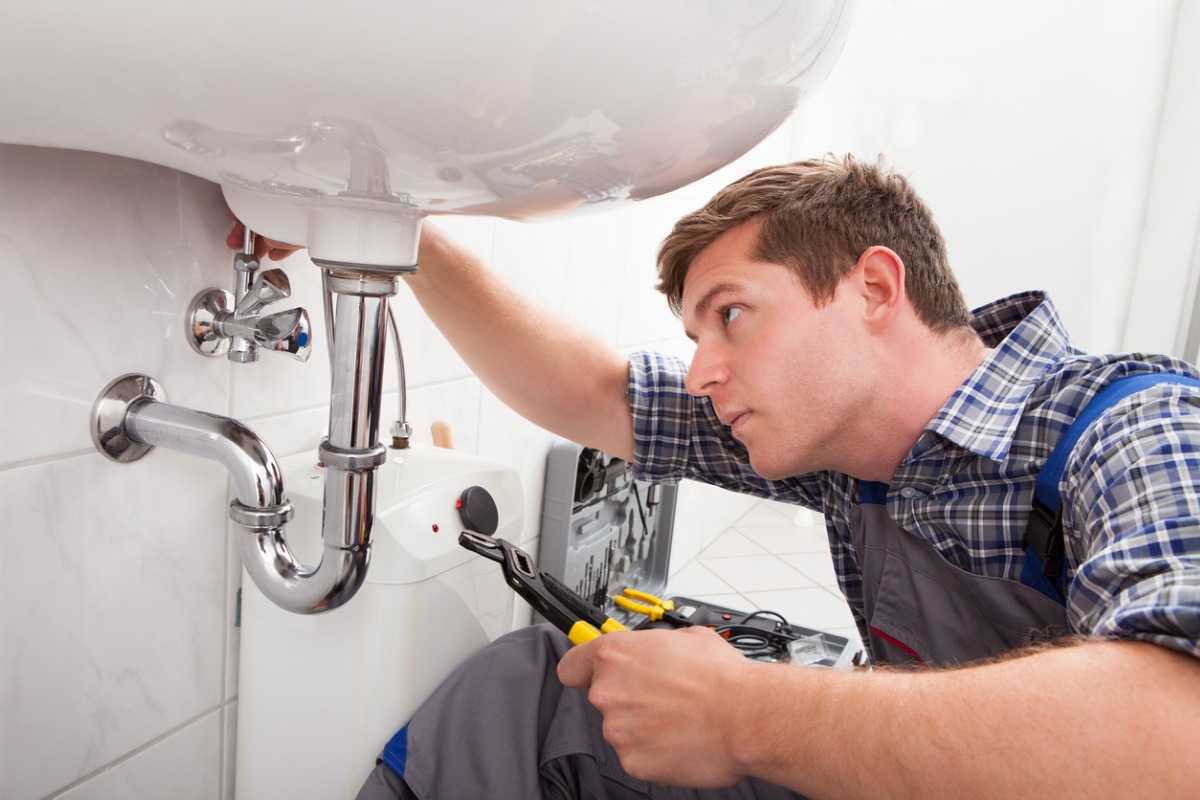 Professional plumber installing pipework 1200x800px